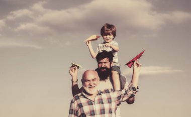 Baba oğul ve büyükbaba birlikte dinleniyorlar. Dedemin oğlu ve torunu parkta eğleniyor. Hafta sonu aile oyunu. Farklı yaşlardaki erkekler..