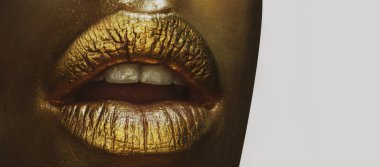 Lüks altın dudaklar makyaj. Altın rujlu altın dudaklar. Seksi kızın dudaklarında altın boya. Şehvetli kadın ağzı, izole bir arka plan. Parlak altın dudaklar..