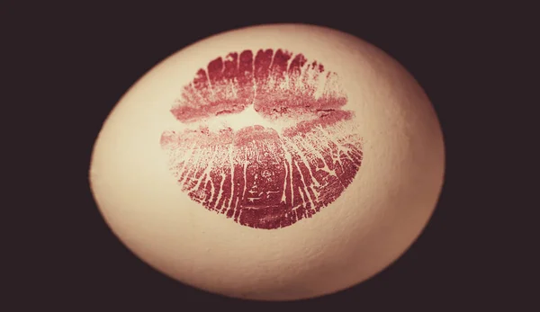 Easter egg siyah arka plan üzerinde kırmızı dudak izi. Kırmızı dudaklı beyaz yumurta üzerinde baskı. Yumurtası avı. — Stok fotoğraf