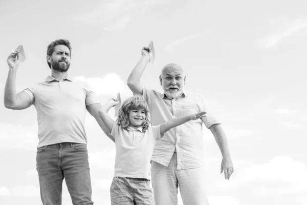 Aktive Familienfreizeit mit Kindern. Sohn mit Vater und Großvater mit Spielzeugflugzeug spielen am Sommerhimmel. Reisekonzept. — Stockfoto