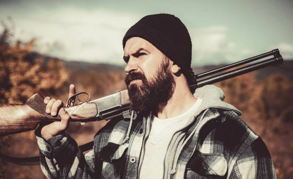 Un chasseur. Période de chasse, saison d'automne. Chasseur avec un fusil de chasse et une forme de chasse pour chasser en forêt. Chasseur avec un sac à dos et un fusil de chasse. Homme tenant un fusil de chasse . — Photo