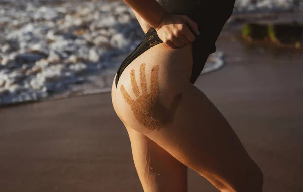 Mooie vrouw lichaamsvorm. Close-up stevige billen in bikini slipje. Close-up zomer foto van zonovergoten zandige vrouw billen poseren op zee van tropische strand achtergrond. — Stockfoto