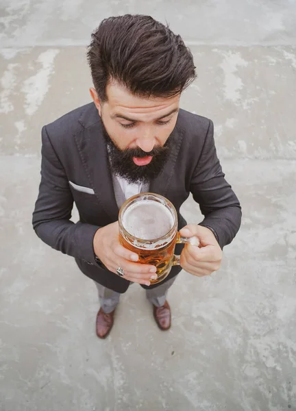 Volle Länge, Weitwinkel. Lustig aufgeregter Mann im klassischen Anzug mit Glas und Bier in der Hand. — Stockfoto
