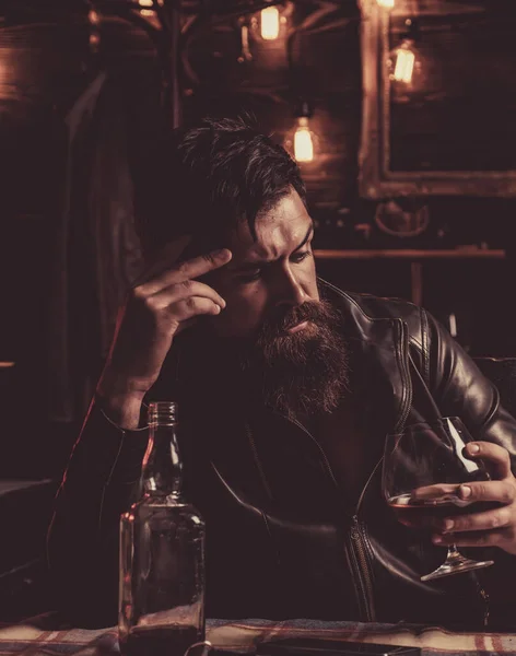 Drinking man. Man with beard holds glass brandy. Man holding a glass of whisky. Sipping whiskey. Degustation, tasting. Macho is drinking whiskey by his laptop.Thinking man. — Stock Photo, Image