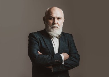 Kolları bağlı, Takım Elbiseli Adam. Sakallı, orta yaşlı, ciddi bir yüz ifadesi olan, yakın plan bir kafa ve omuz portresi olan adam..