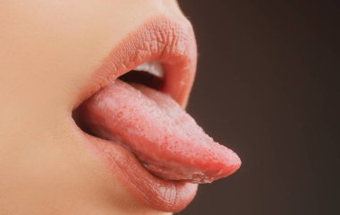 Şehvetli baştan çıkarıcı ağız kapanışı. Kadın seksi bir dil gösteriyor..