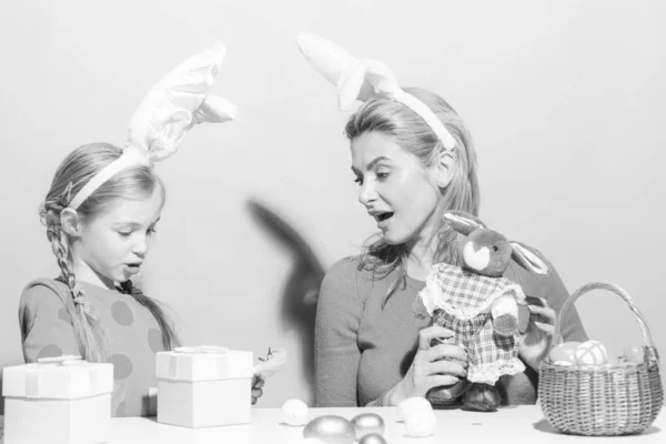 Veselé Velikonoce. Matka a dcera začnou lovit velikonoční vajíčka. Šťastná rodina se připravuje na Velikonoce. Roztomilá holčička nosí králičí uši o velikonočním dni. — Stock fotografie
