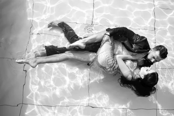 사랑하는 로맨틱 한 커플 이 수영장에서. 수영장에서 파티를 했지. 품위있는 두 쌍의우아 한 사람들. 수영장에서의 유행하는 부부. — 스톡 사진
