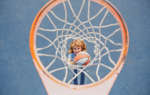 Úhel pohledu z vrcholu dítěte hraje basketbal na hřišti. — Stock fotografie