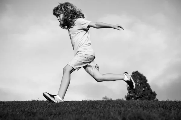 Bambino divertente correre all'aperto. Un ragazzino che gioca nel parco estivo. Ragazzino che corre sul campo di erba fresca verde. — Foto Stock