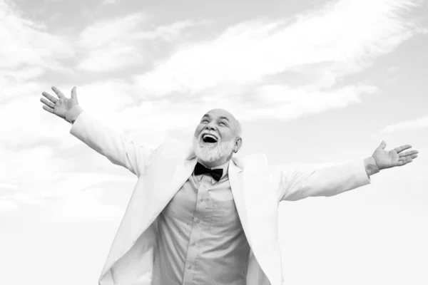 Carefree life winner old mature man. Vintage success male in white suit having fun on sky background. — Stock Photo, Image