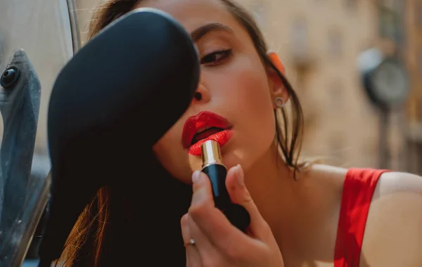 Cidade moda vida. Menina sexy com lábios vermelhos colocar batom olhando em um espelho de moto. Vogal de rua. — Fotografia de Stock