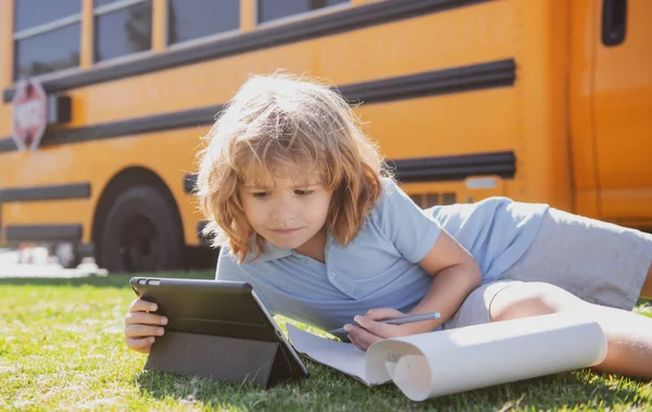 Schüler schreiben Hausaufgaben mit Laptop im Freien in der Nähe des Schulbusses. Fernstudium Online-Bildungskonzept. — Stockfoto