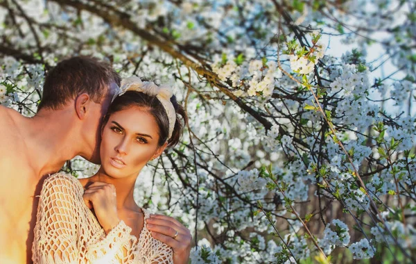 Casal de primavera apaixonado. Felicidade de verão. Amantes sensuais na árvore de flor de cereja. — Fotografia de Stock