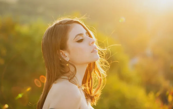 Cerca de la cara de la mujer joven y elegante. Hermoso retrato al aire libre chica de moda. Mujer joven al aire libre disfrutando de la luz del sol. Mujer joven en el soleado día de primavera, colores suaves y soleados. — Foto de Stock