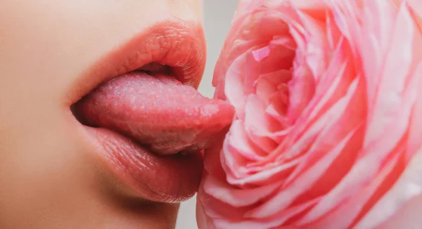 Ajkak nyelvvel közelről. Gyönyörű nő ajkak rózsával. Szexi ajkak. A nők makrója arcrész. Szexi fényes ajak smink. Szépség piros ajak smink részlet. — Stock Fotó