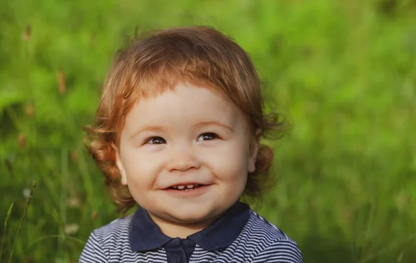 Lifestyle portret baby kind in gebeurt aan de buitenkant in de wei. Baby gezicht van dichtbij. Grappig kinderportret. Blond kind, emotie gezicht. — Stockfoto