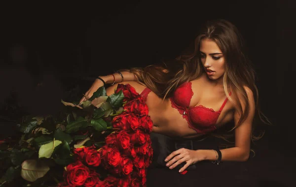 Hermosa mujer con flores de rosas. Chica con ramo de rosas en el estudio en negro. — Foto de Stock