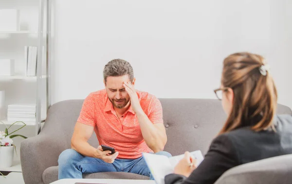 Mężczyzna omawiający swoje problemy psychologiczne z psychiatrą podczas sesji terapeutycznej. Doradztwo dla pracowników socjalnych. — Zdjęcie stockowe