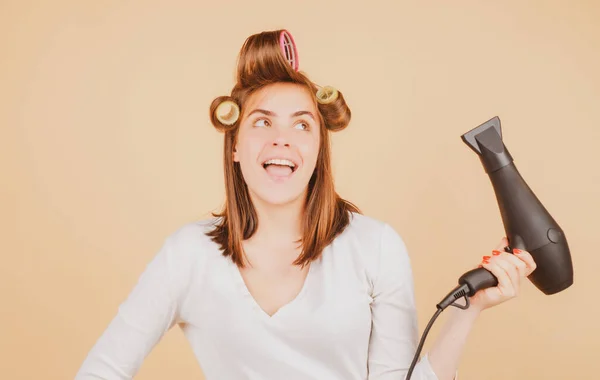 Amazed woman with hair dryer. Excited girl with straight hair drying hair with professional hairdryer.