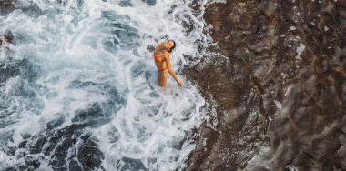 Denizde, dalgaların yanında bir kadın. Üst Manzara, Hava Çekimi.