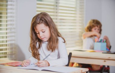 Eğitim, ilkokul, öğrenim ve insan konsepti, elinde kalem ve defter olan bir grup okul çocuğu..