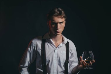 Viski, konyak, konyak içen bir adam. Degukasyon ve tatma. Bir bardak konyaklı adam. Bir bardak viskisi olan erkek model..