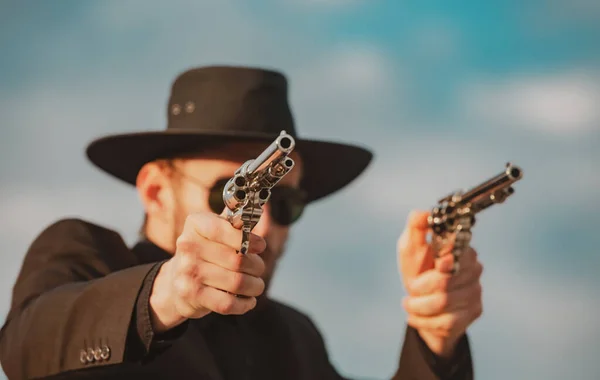Sheriff in black suit and cowboy hat shooting gun, close up western portrait. Wild west, western, man with vintage pistol revolver and marshal ammunition. — Stock Photo, Image