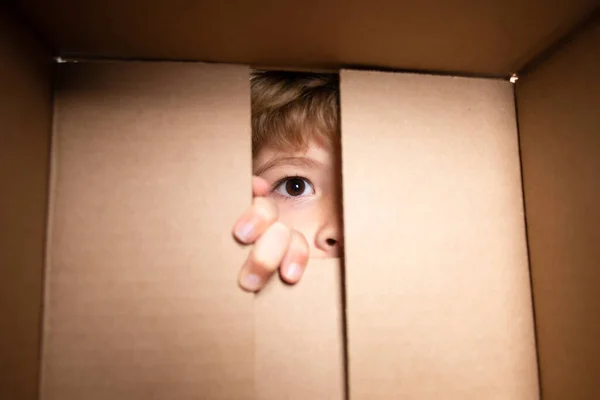 Niño de 6 años abierto caja de entrega de cartón, embalaje abierto y cerrado caja de cartón. Concepto de embalaje o desembalaje de paquetes. Imagen de stock