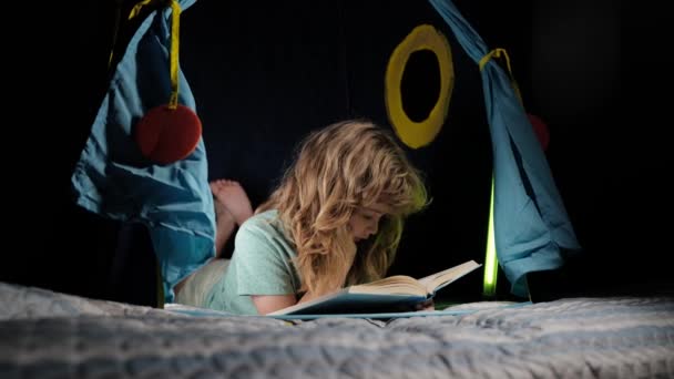 Dzieci w namiocie czytają książki. Szczęśliwe dzieciństwo, śniące dziecko czytające bajki na dobranoc, bajki lub bajki. — Wideo stockowe