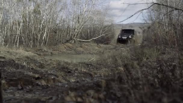 Neumático de camión todoterreno sucio con lodo húmedo y seco con borde. Neumáticos sucios en el barro. Salpicaduras de barro y agua en las carreras off-road. — Vídeo de stock