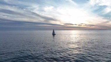 Mavi açık denizde ya da okyanusta seyreden bir teknenin drone görüntüsü. Mavi denizde yüzen lüks teknenin havadan görünüşü. Okyanusta yelkenli.