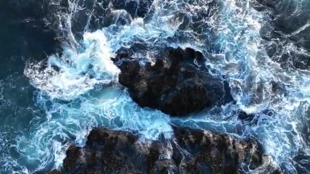 Aguas coloridas del océano, giran alrededor de la costa rocosa y pintoresca. Olas marinas rompiendo sobre rocas. — Vídeo de stock