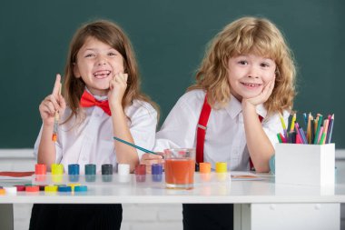 Resim okulu öğrencileri resim ödevi yapıyor. Çocuklar ilkokulda resim çiziyor. Çocukluk eğitimi, çocukların sanatsal becerileri..