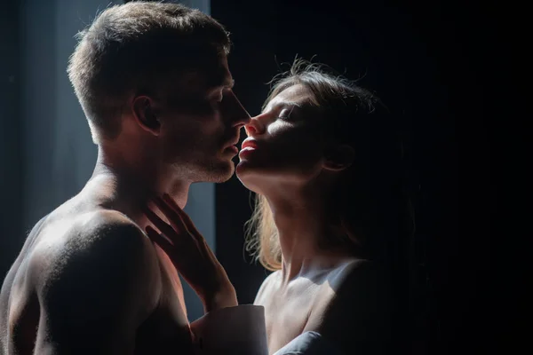 Passionate kiss. Man embracing and going to kiss sensual woman. Loving couple kissing over black background. Real love on Valentines Day. — Stock Photo, Image