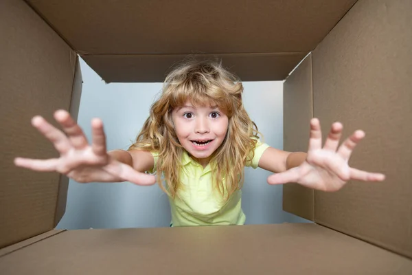 Bambino felice con scatola di cartone, pacco disimballaggio da internet store. Cliente per bambini soddisfatto del servizio di consegna veloce. Espressione bambini volto sorpreso. — Foto Stock