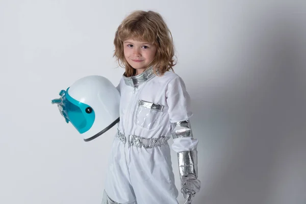 Kleine astronaut. schattig kind ruimtevaarder, kind in de ruimte pak holding helm geïsoleerd op grijze achtergrond. — Stockfoto