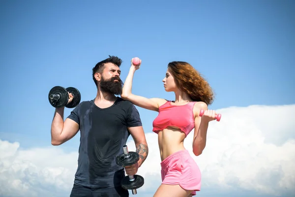 Entrenamiento de hombre y mujer con mancuernas, deporte atlético, ejercicio en pareja al aire libre. —  Fotos de Stock