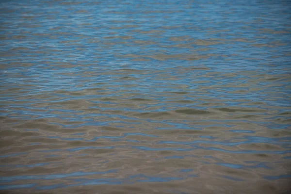 Fondo de textura de agua de mar abstracto o ondulado. Calma textura de la superficie del agua con salpicaduras y olas. Fondo abstracto de la naturaleza. Superficie de agua azul del océano. — Foto de Stock