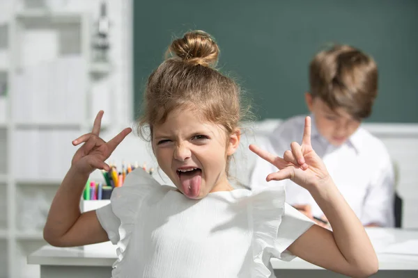 Portret van aantrekkelijke gekke grappige meisje in de klas op de basisschool. — Stockfoto