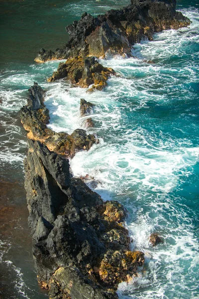 Lava resfriada e ondas oceânicas. Vista das ondas do mar atingindo rochas na praia. Ondas e rochas. — Fotografia de Stock