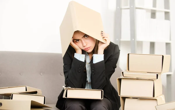 Rušná mladá podnikatelka, frustrovaná sekretářka se složkou na hlavě, která pracuje přesčas. Tajemnice účetní žena pracuje sama pozdě v úřadu. — Stock fotografie