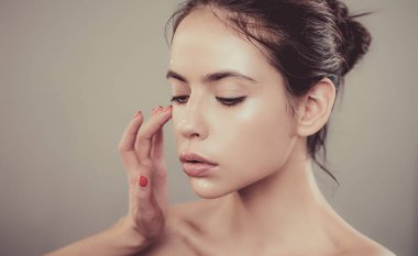 Profesyonel makyöz, vizör ve stilistlik işi. Güzellik salonu konseptinde müşteri hizmetleri. Güzel genç kadın modeli doğal çıplak makyajını yaptırıyor..