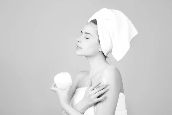 Retrato de cara de belleza. Terapia de spa, hermosa mujer en toalla con productos cosméticos. — Foto de Stock