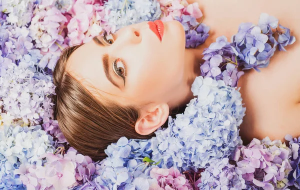 Makeup cosmetics and skincare. Nature beauty. Woman lying on flowers. Unity with nature. Blossom. Girl with hydrangea flowers. — Stock Photo, Image