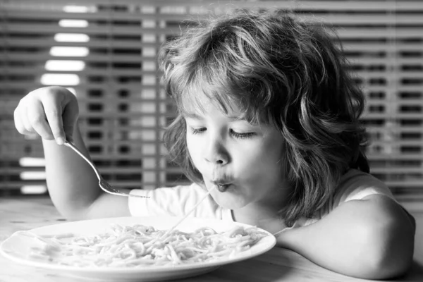Sluit een foto van een kind dat pasta eet, spaghetti. Kinderen gezicht, kleine jongen portret. — Stockfoto