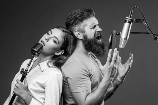 Zpěváci zpívají rock. Zvuková producentka nahrává písničku v hudebním studiu. Nadšený duet Karaoke. — Stock fotografie