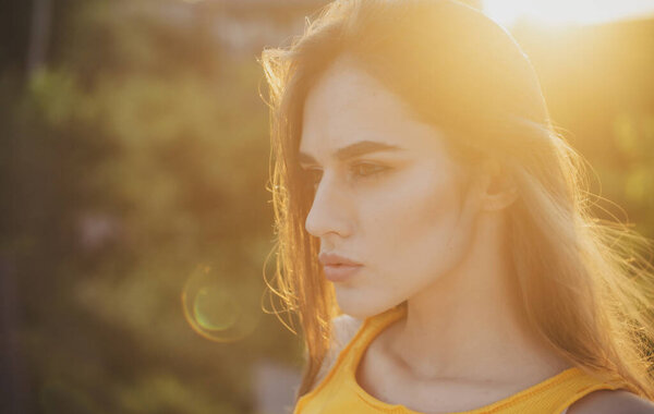 Beautiful young woman posing outdoor. Stylish girl in summer casual outfit. Outdoor female portrait.