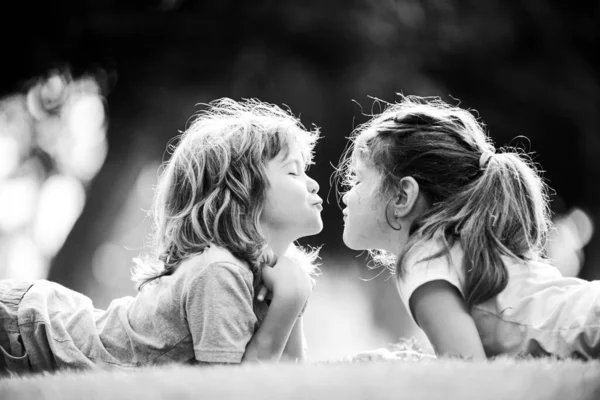 Relaciones con niños. Lindo amor. Niños pequeños besándose al aire libre en el parque. —  Fotos de Stock