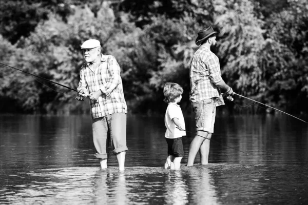 何世代も。祖父と父と息子は川でフライフィッシングをしている. — ストック写真